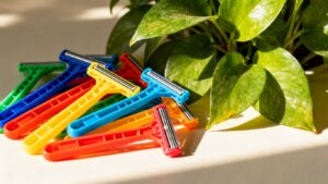 Plastic razors and a green plant